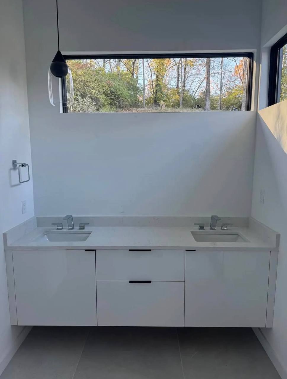 Floating vanity with two basins and wall-mounted cabinetry.
